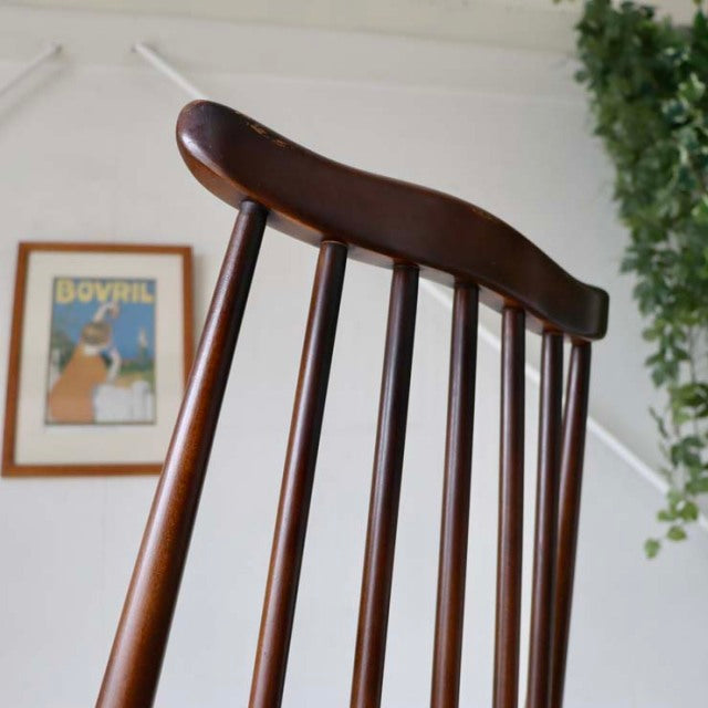 Vintage British mid-century teak dining chair with curved top rail and slender spindled backrest.