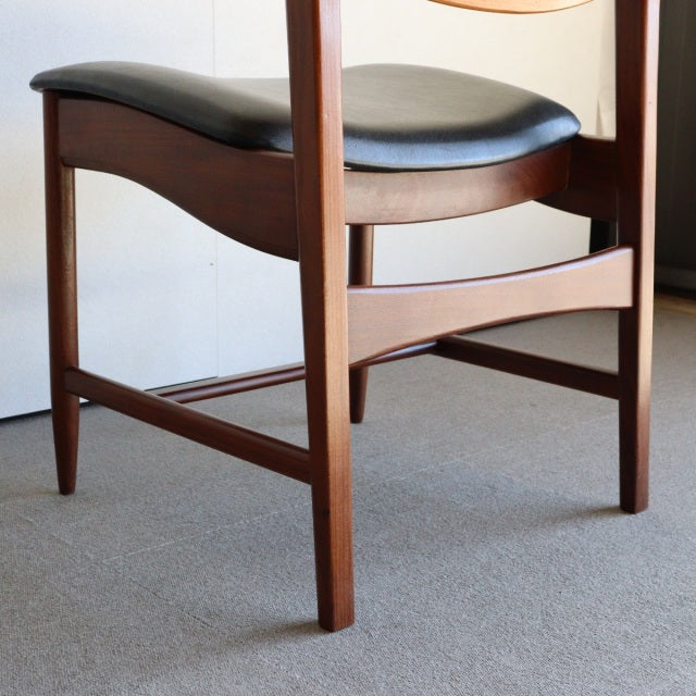 Mid-century British vintage teak dining chair with black leather seat and tapered legs.