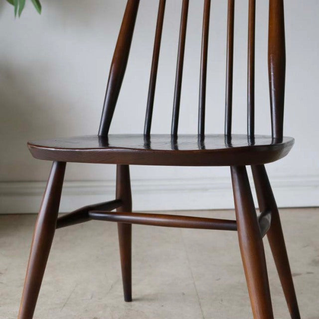 Vintage British mid-century dining chair in teak with slender spindle back and tapered legs.