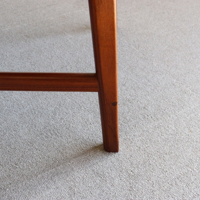 Mid-century teak leg from British vintage dining chair with rich wood grain and warm finish.