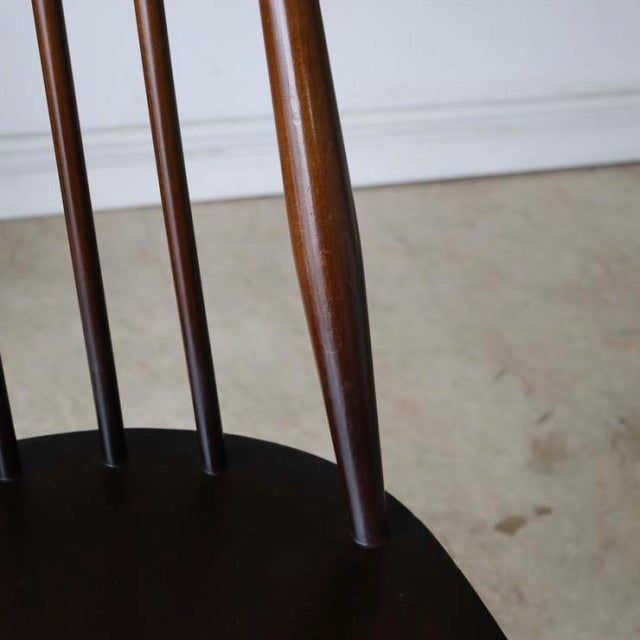 Mid-century British vintage Ercol Goldsmith dining chair in rich teak with slender spindle back and tapered legs showing.