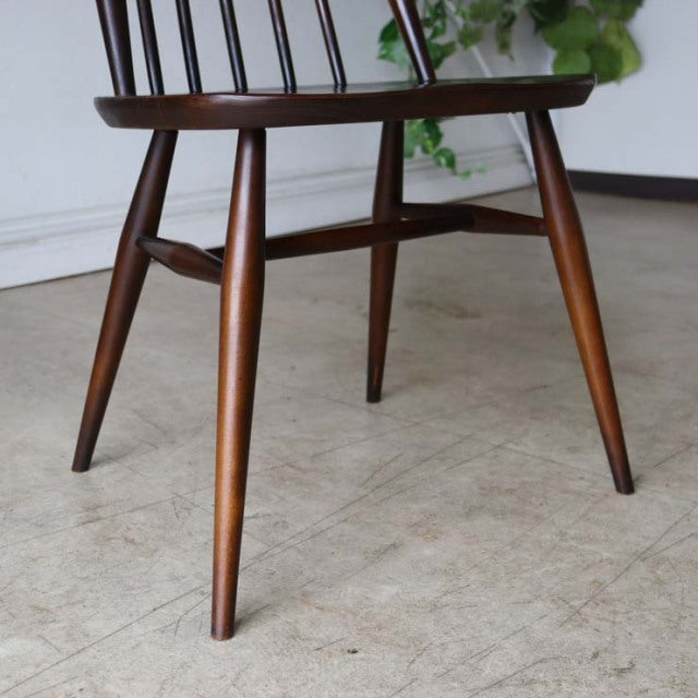 Mid-century British vintage Ercol Goldsmith dining chair in warm teak with visible wood grain and tapered legs.