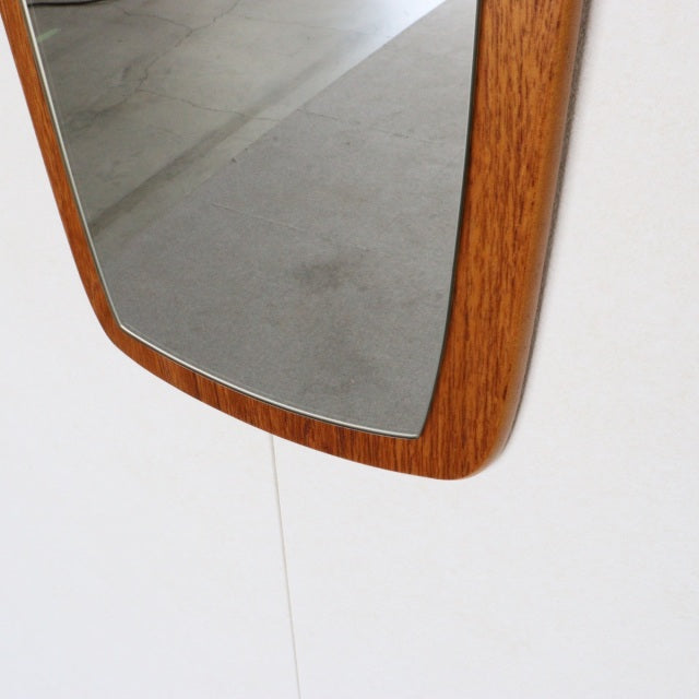 Vintage mid-century British teak wall mirror with elongated rectangular frame and visible wood grain.