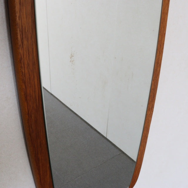 Vintage mid-century British teak wall mirror with slender elongated frame and warm wood grain finish.