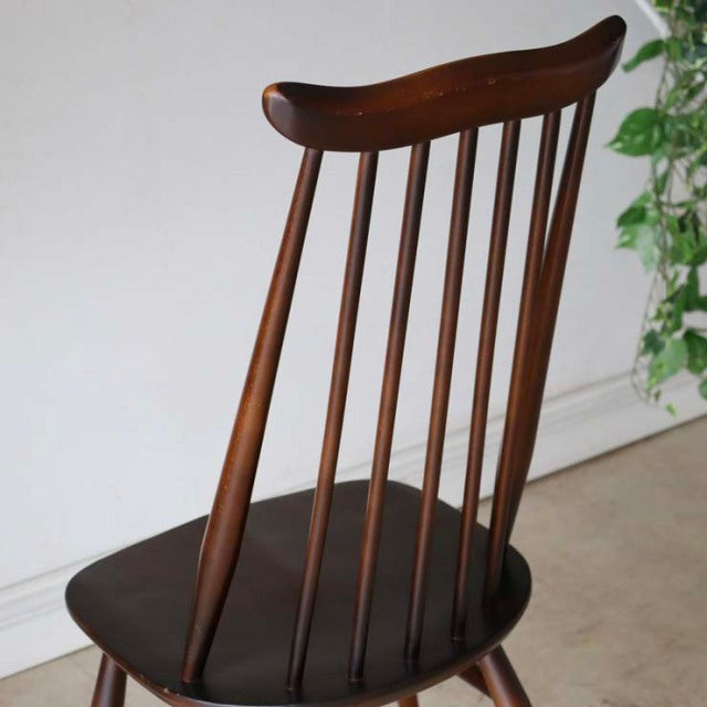 British mid-century vintage Ercol dining chair in rich teak with slender spindle backrest and gently curved top rail.