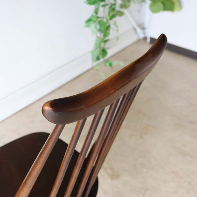 Vintage British Ercol Goldsmith dining chair in rich teak with curved top rail and slender spindle back, showcasing.