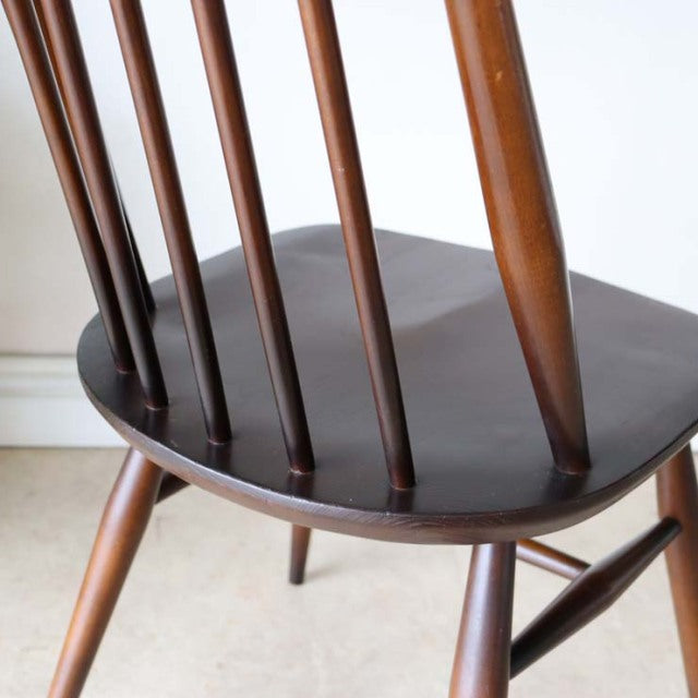 Vintage British mid-century teak dining chair by Ercol with tapered legs and smooth curved backrest spindles.