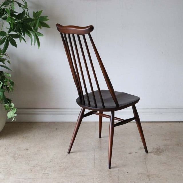 Vintage British mid-century dining chair in teak with a curved backrest, slender vertical spindles, and tapered legs.
