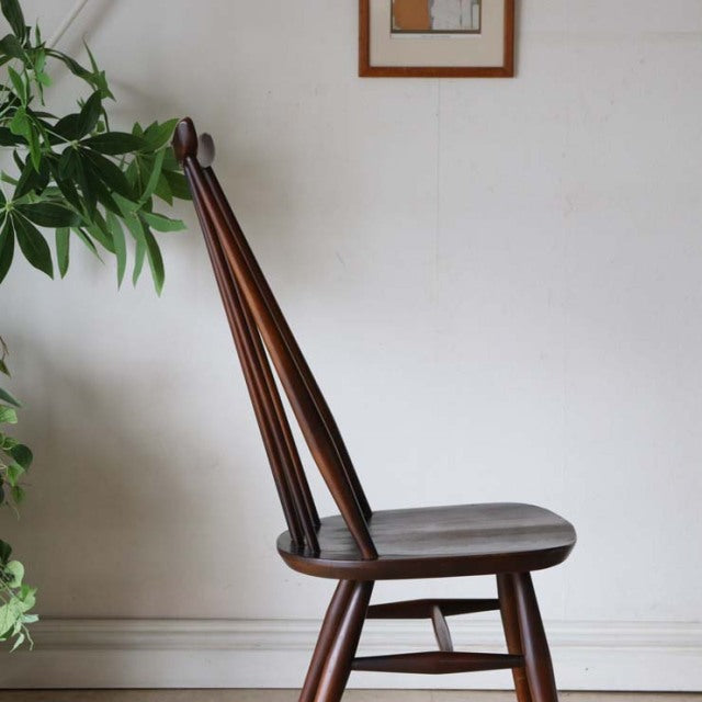 Vintage British mid-century teak dining chair by Ercol with tapered spindle back and rounded seat.