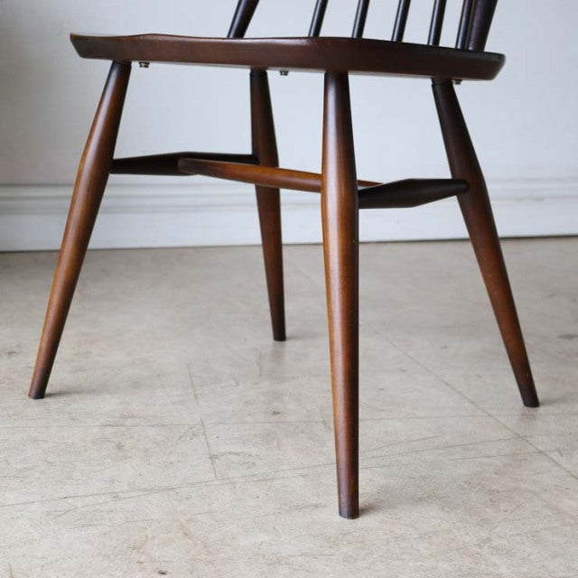 Mid-century British vintage teak dining chair with slender tapered legs and smooth wood grain finish.