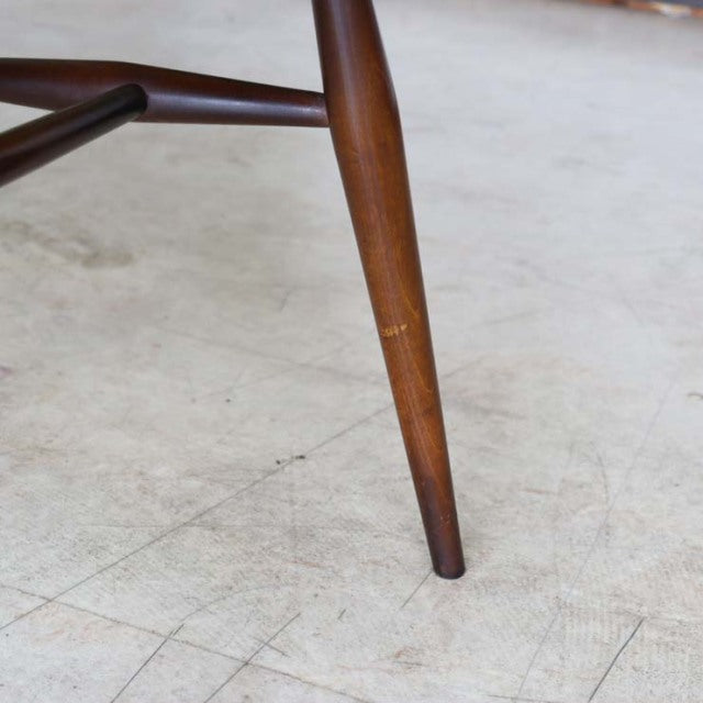 Mid-century British vintage teak dining chair leg with smooth wood grain and slender tapering design.