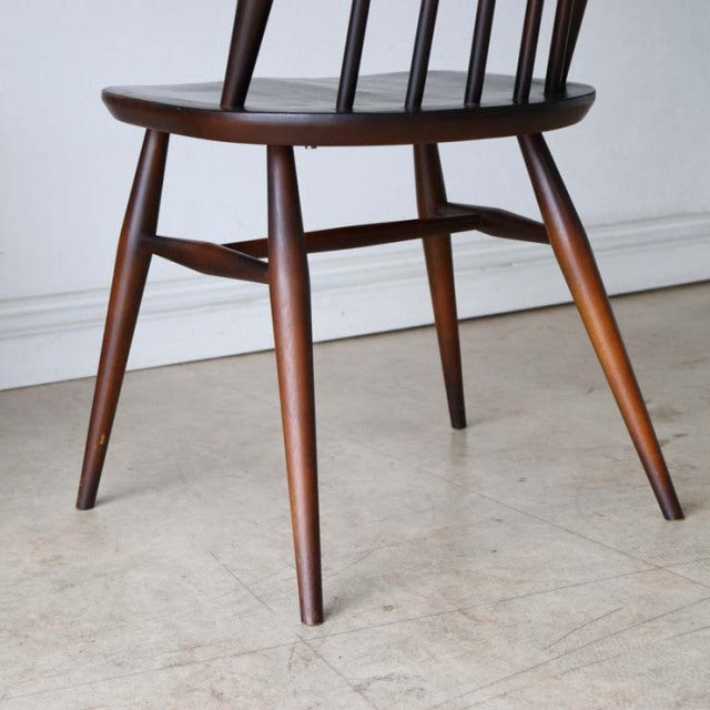 Mid-century British vintage Ercol Goldsmith dining chair in teak with slender tapered legs and visible wood grain.