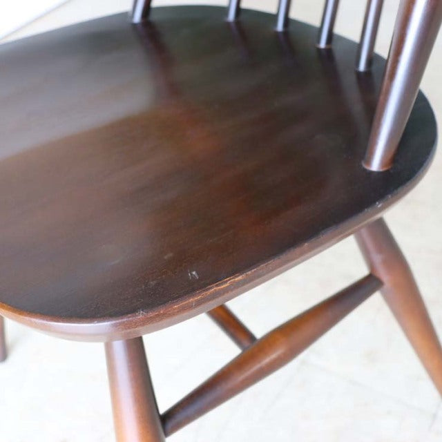 Close-up of vintage British Ercol Goldsmith dining chair seat in rich teak with smooth wood grain and rounded edges,.