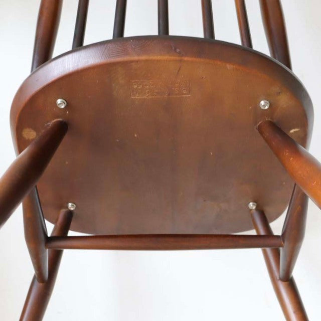 Underside of vintage British Ercol Goldsmith teak high-back chair showing rich wood grain and sturdy spindle legs.