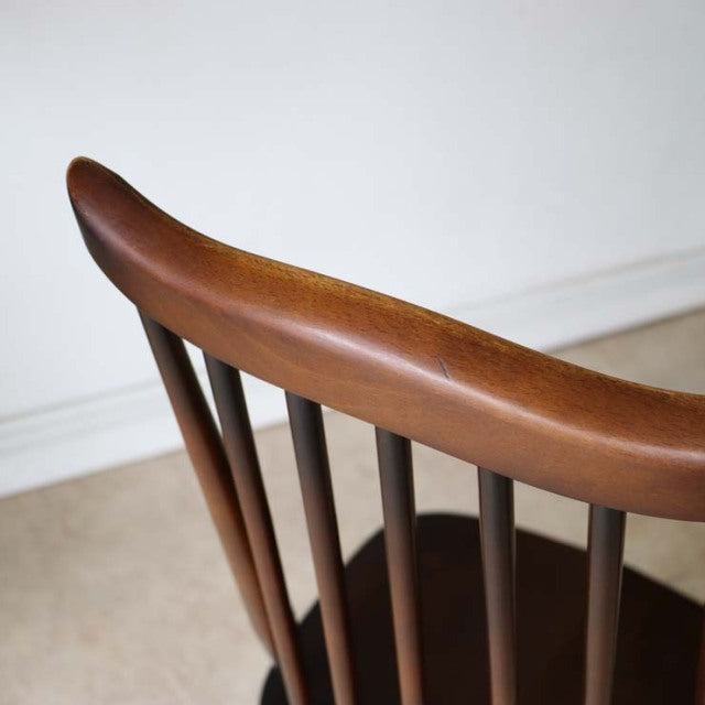 Vintage British mid-century teak dining chair with curved top rail and slender spindled backrest.