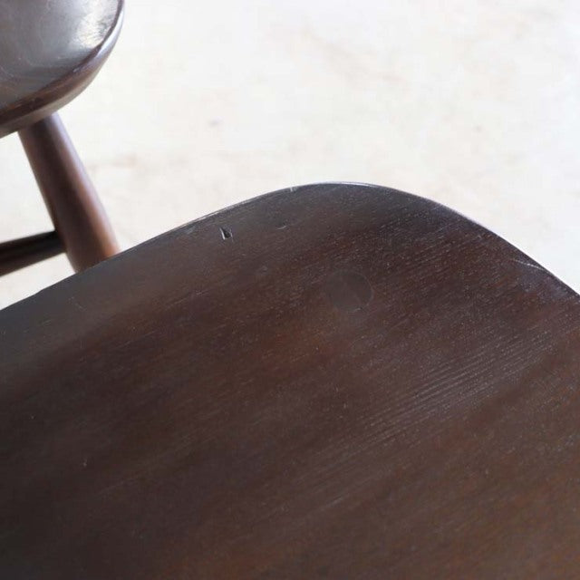 Vintage British mid-century dining chair in dark teak with smooth wood grain and rounded seat edge.