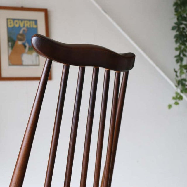 British mid-century Ercol Goldsmith dining chair in vintage teak with curved top rail and slender spindle backrest.