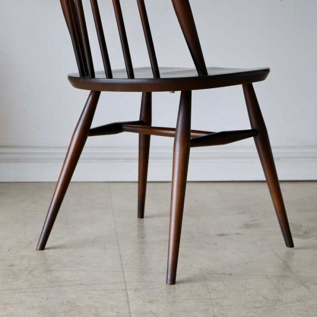 Set of four vintage British Ercol Goldsmith high-back dining chairs in teak with slender tapered legs and visible wood.
