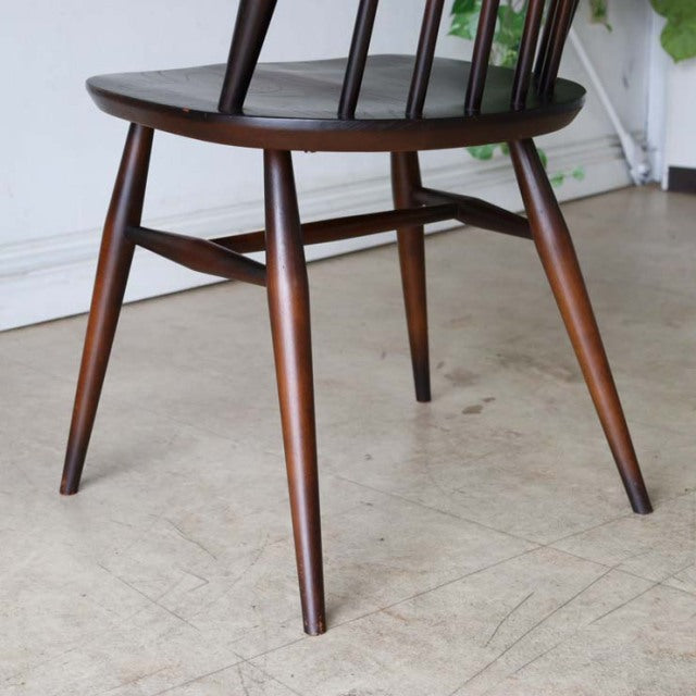 Vintage British mid-century teak dining chair with tapered legs and smooth curved seat edges, showcasing rich wood grain and .