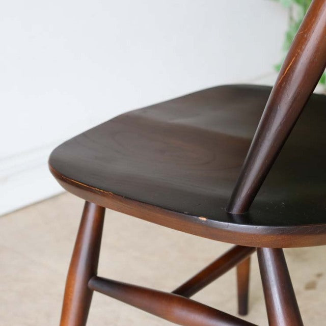 Vintage mid-century British Ercol Goldsmith dining chair in rich teak with curved seat and tapered legs showing wood grain.