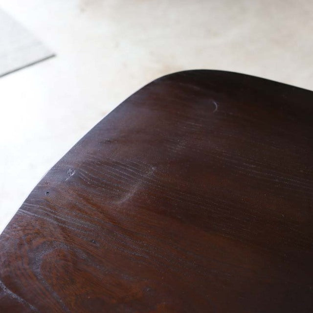 Close-up of vintage British Ercol Goldsmith dining chair seat showing dark teak wood grain with smooth finish and subtle.