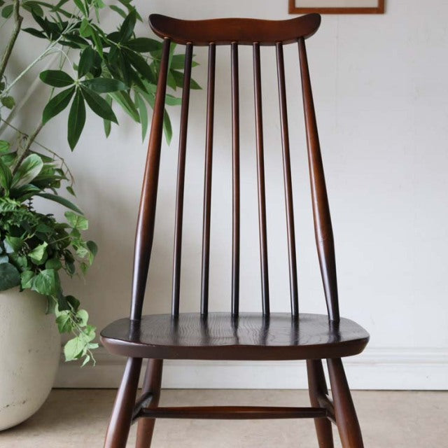 Vintage British mid-century Ercol dining chair in teak with slender spindle back and tapered legs.