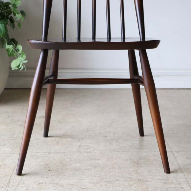 British vintage mid-century teak dining chair with tapered legs and spindle backrest.