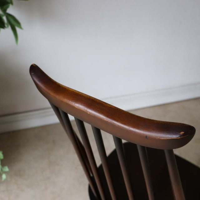 Vintage British mid-century teak dining chair by Ercol with curved top rail and slender spindled backrest.