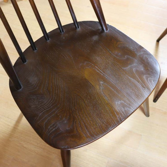 Vintage mid-century British Ercol Goldsmith dining chair in rich teak with curved spindled back and smooth contoured seat.