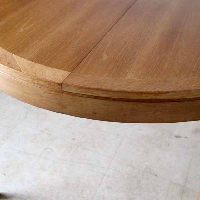 Vintage teak round dining table with smooth wood grain and tapered mid-century British legs.