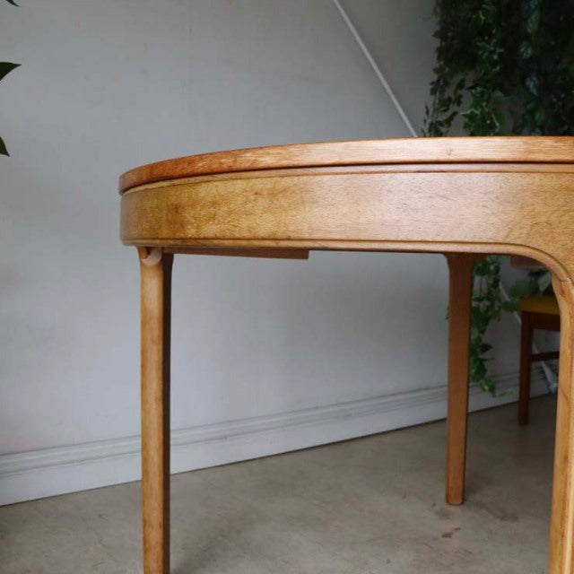 Vintage teak Nathan round dining table with smooth wood grain, slender British mid-century legs, Danish design influence.