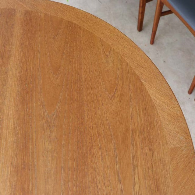 Vintage teak round dining table with smooth wood grain and British mid-century Danish design.