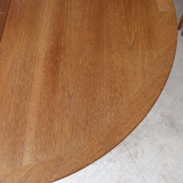 Vintage mid-century teak dining table by Nathan, round top with rich wood grain, British-Denmark style, sturdy tapered legs.
