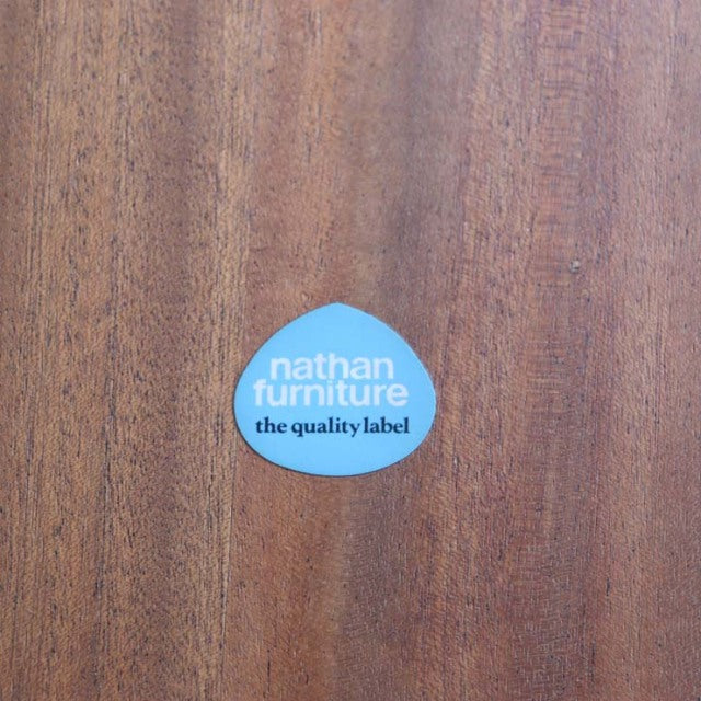 Round vintage teak dining table top with rich wood grain and Nathan Furniture blue logo label.