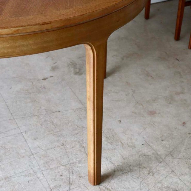 Vintage teak round dining table leg showcasing smooth wood grain and elegant mid-century British design with tapered form.