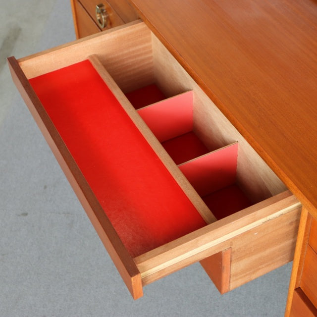 Mid-century British vintage teak dresser drawer with red felt lining and natural wood grain interior dividers.