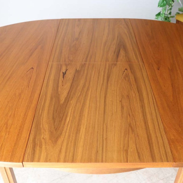 Vintage Alfred Cox round dining table in teak with mid-century British design, smooth wood grain and clean edges.