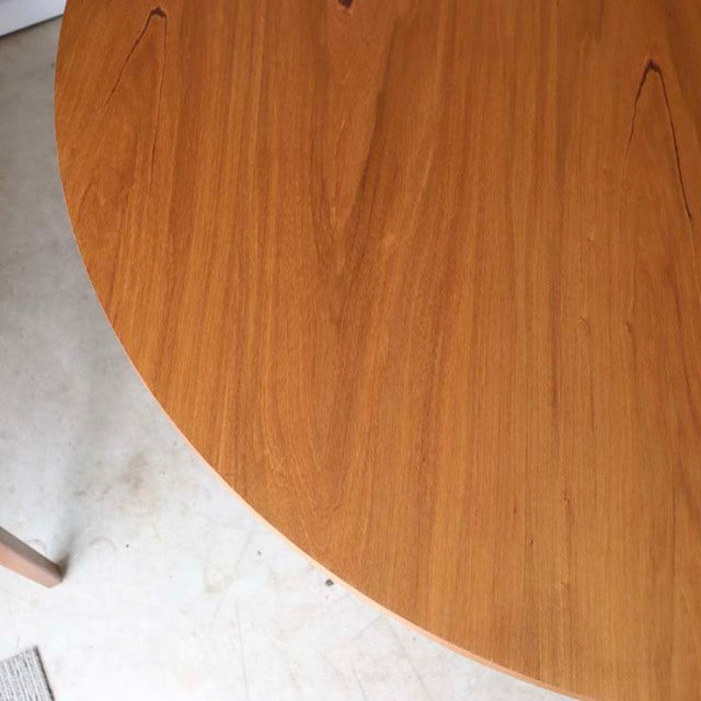 Round vintage teak dining table by Alfred Cox, showcasing smooth wood grain and mid-century British-Denmark design with.