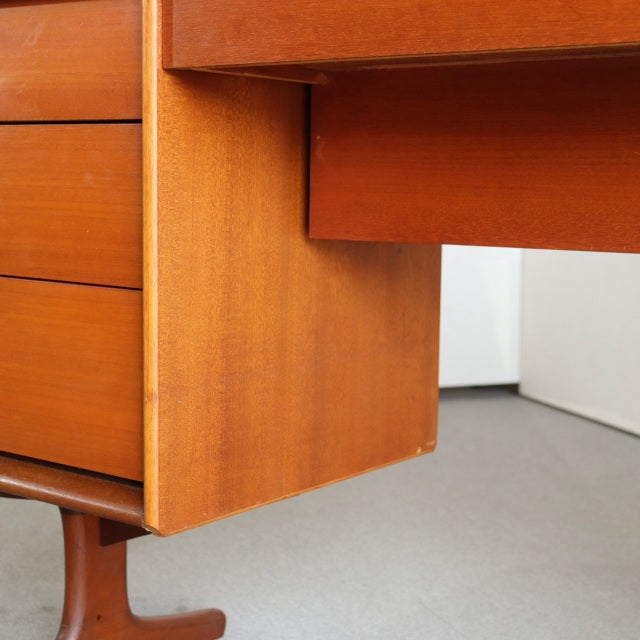 Mid-century British vintage teak dresser corner showing smooth wood grain, clean lines, and tapered legs.