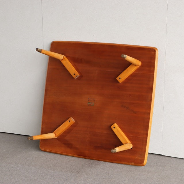 Square mid-century vintage teak coffee table from Denmark with tapered wooden legs and warm wood grain finish.