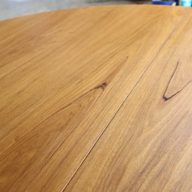 Vintage Alfred Cox British mid-century teak round dining table top with visible wood grain and natural knots.