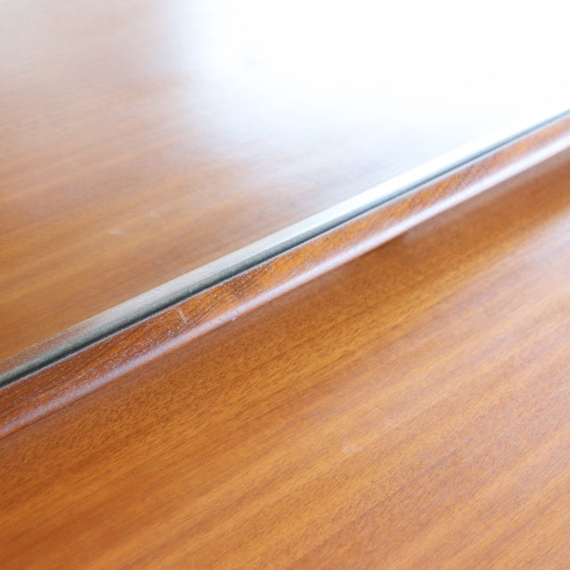 Close-up of vintage mid-century British teak dresser top showcasing smooth wood grain and sleek linear design with subtle.