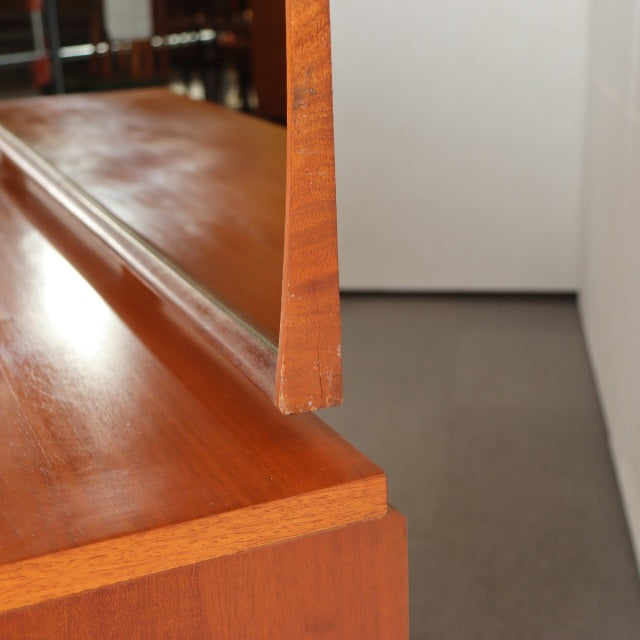 Close-up of vintage mid-century British teak dresser showing wood grain and mirror edge detail from Austinsuite.