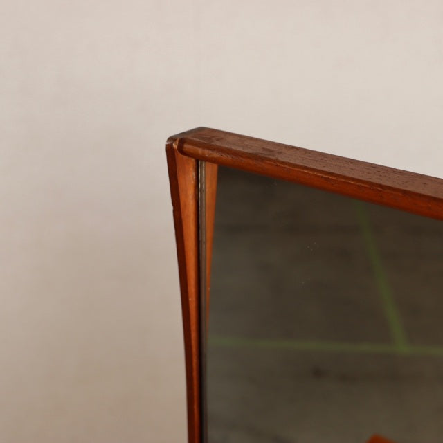 Close-up of vintage mid-century teak dresser mirror with British and Danish design influences, showcasing rich wood grain.