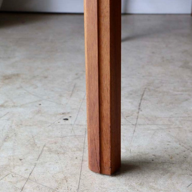 Close-up of vintage teak dining table leg with clean lines and fine wood grain, British mid-century style.