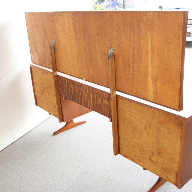 Mid-century British vintage teak dresser with rich wood grain, tapered legs, and extendable leaves from Austinsuite.