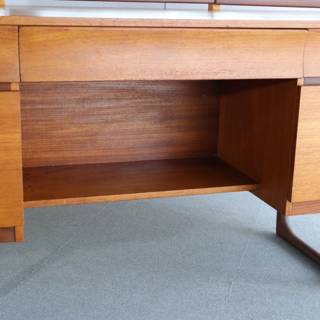 Mid-century British vintage teak dressing table with rich wood grain, open shelf, and slender curved legs.