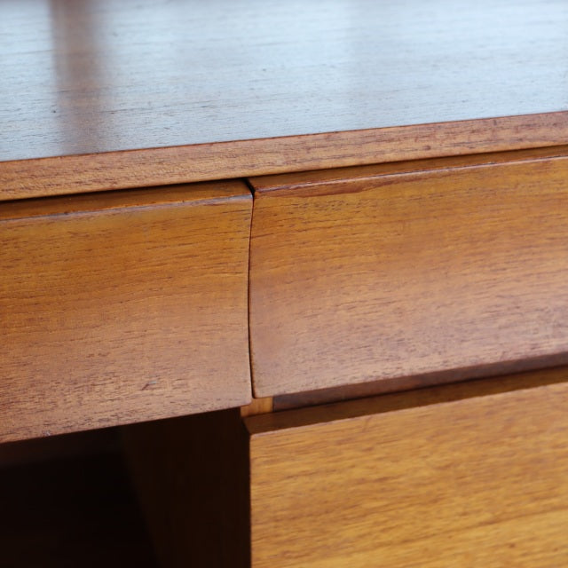 Vintage teak mid-century British dresser detail showing smooth wood grain and curved drawer edges from Durable Suites.
