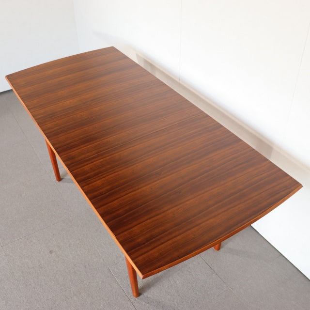 Vintage British mid-century teak dining table with rectangular top, rich wood grain, and tapered legs.