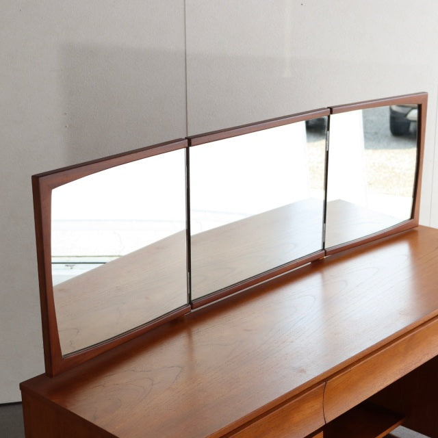 Mid-century British teak dresser from Durable Suites featuring three rectangular mirrors with angled edges and rich wood.